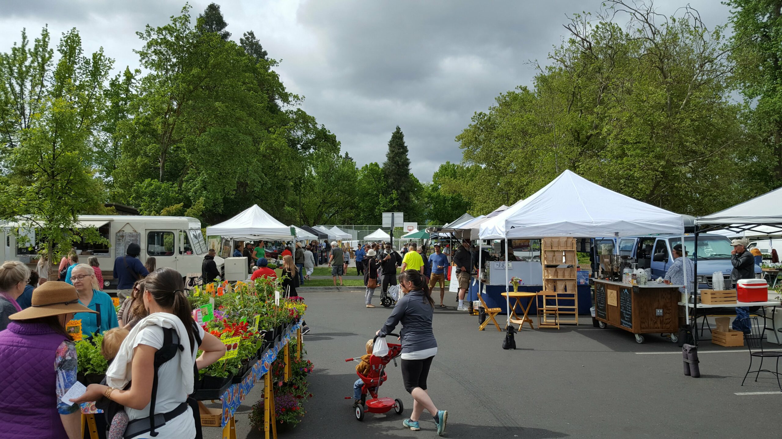 Rogue Valley Growers & Crafters Market Woman pushing stroller at an outodoor parket