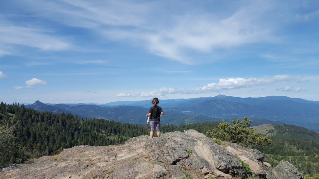 Little girl standing on a mountain top.